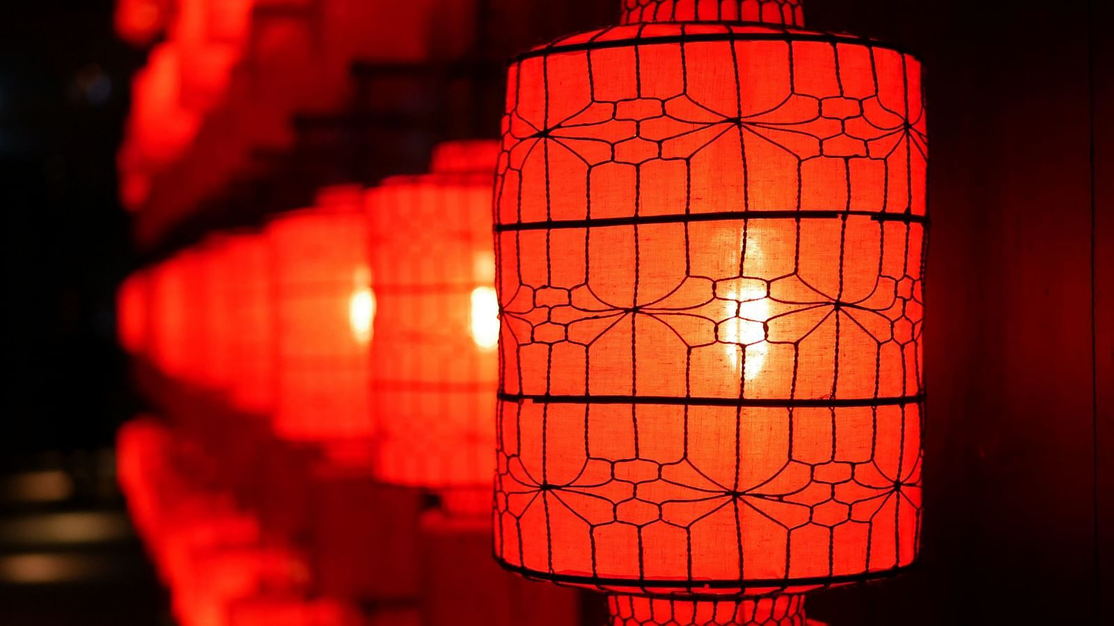many red lanterns in a single line with a flame inside