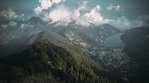 a view of mountains and white clouds next to them with blue sky in the background
