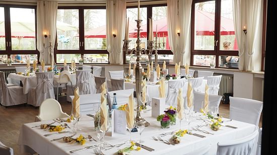 Event space with round tables, white tablecloths, and centrepieces.