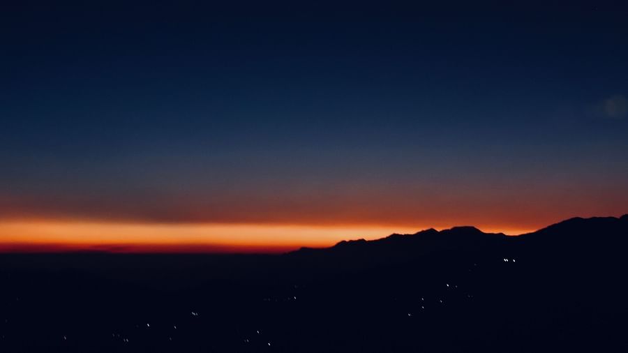  A dark twilight sky, with a faint sunset glow lingering on the horizon, creates a sense of mystery and tranquility, possibly a view from the resort's location as night descends