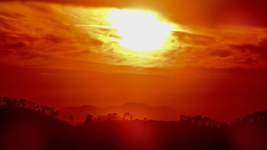 The sun bursts through the clouds, casting a warm, golden glow across the landscape, illuminating the surrounding hills and valleys, potentially a stunning view from the resort