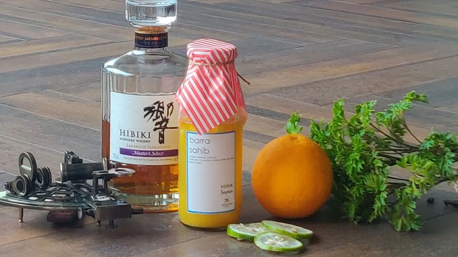 two bottles of alcohol kept along with an orange - polo floatel kolkata