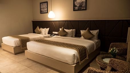 view of a king size bed and a single bed at Executive Tripple Room at Cholaa Dynasty, Kumbakonam