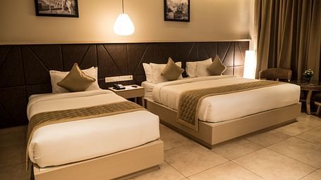 view of a king size bed and a single bed at Executive Tripple Room at Cholaa Dynasty, Kumbakonam