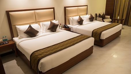 Corner view of a Luxury Suite featuring a close-up of a double bed and elegant curtains.