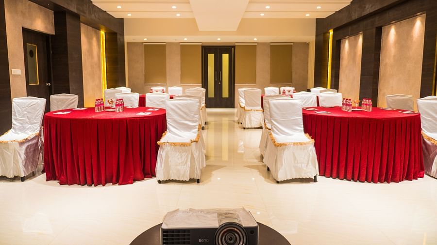 event hall with red tables and white satin chairs of ASR Parklane, Hosur
