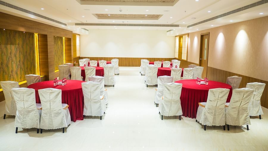 event hall with red tables and white satin chairs of ASR Parklane, Hosur