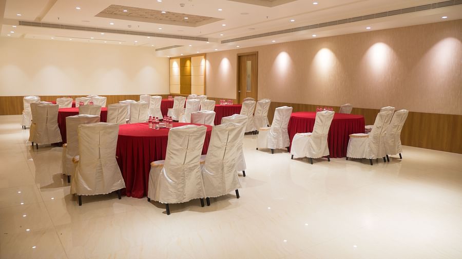 event hall with red tables and white satin chairs of ASR Parklane, Hosur