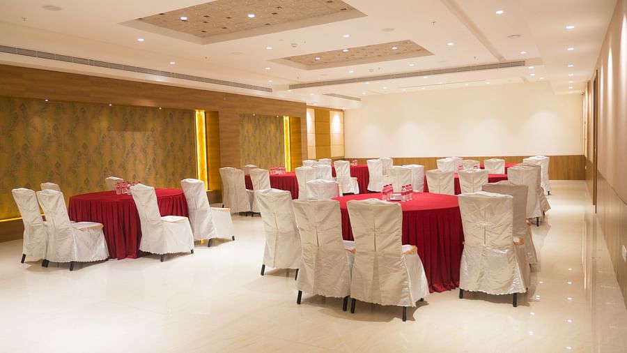 event hall with red tables and white satin chairs of ASR Parklane, Hosur