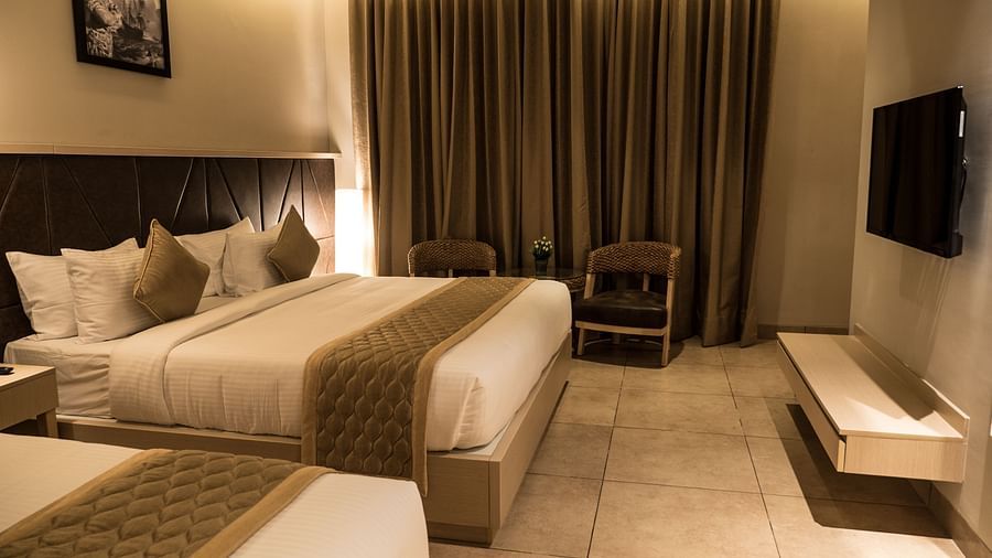 view of a king size bed and a single bed at Executive Tripple Room at Cholaa Dynasty, Kumbakonam