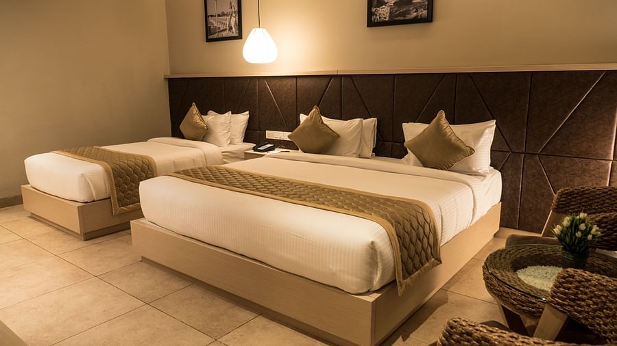 view of a king size bed and a single bed at Executive Tripple Room at Cholaa Dynasty, Kumbakonam
