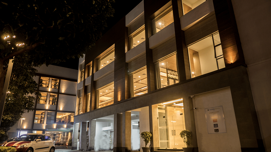 Illuminated facade of Khanna Fiesta, Vellore at night with multiple windows and an entrance door.
