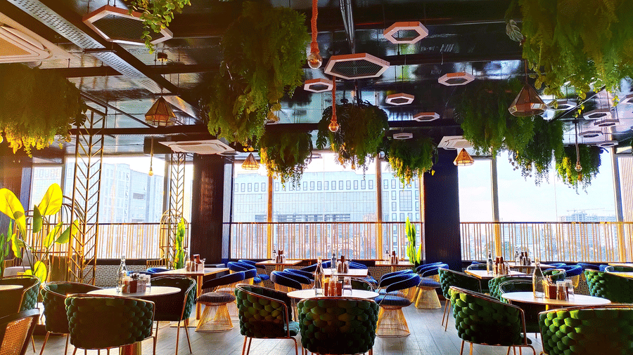 Full view of the dining area at Kensho rooftop pub featuring well-arranged dining tables overlooking the mesmerising city views from the window.