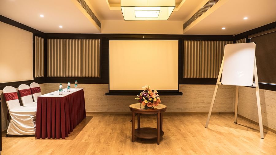 white board and a screen projector with chairs pointed at the board of even hall of MM Legacy, Kanchipuram