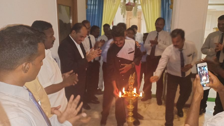 A group of people around a lighted lamp at SRM Hotel Tiruchirappalli- Hotel 