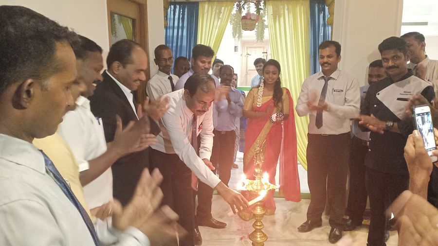 A group of people clapping as a man lights a candle at SRM Hotel Tiruchirappalli- Hotel 