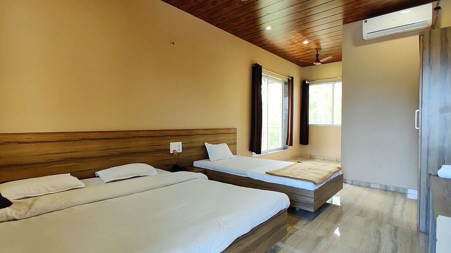 Triple Premium Room at The Kanila Resort featuring a bed with a headboard and white sheets and a window.