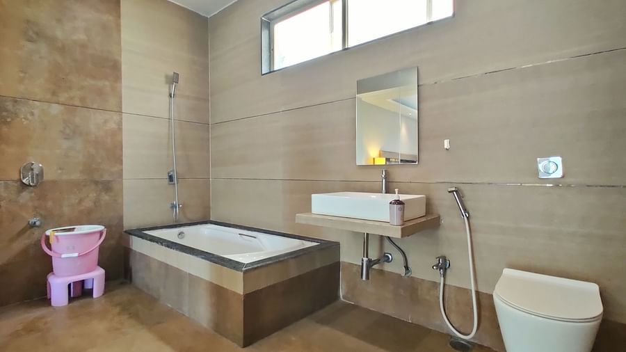 Bathroom of Super Premium Room at The Kanila  Resort  featuring a bathtub in the corner along with a toilet.
