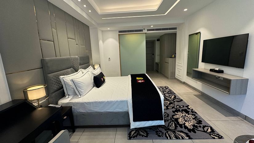 an image of a deluxe room with a television and a wardrobe at Mastiff Select Mandavya Dharamkot, McLeodganj
