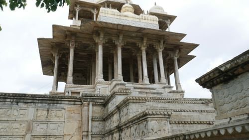 An overview of a cenotaph inside a historical building with white clouds in the background