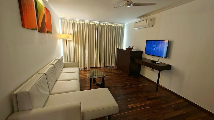 Corner view of Suite Room with a large cosy sofa and a TV mounted on the wall at Springs Hotel & Spa