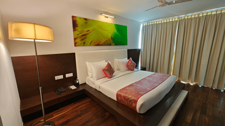 Well lit Suite with a luxurious king sized bed and a bedside lamp beside it at Springs Hotel & Spa, Bangalore