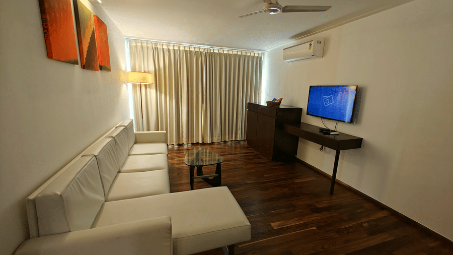 Corner view of Suite Room with a large cosy sofa and a TV mounted on the wall at Springs Hotel & Spa