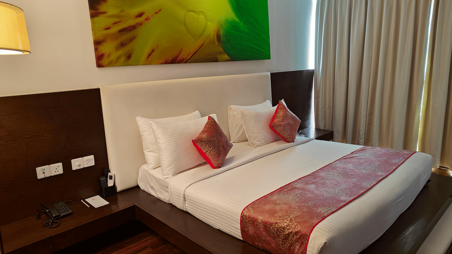 Suite with a king size bed with a wall hanging over its headboard and a telephone on the nightstand beside it at Springs Hotel & Spa