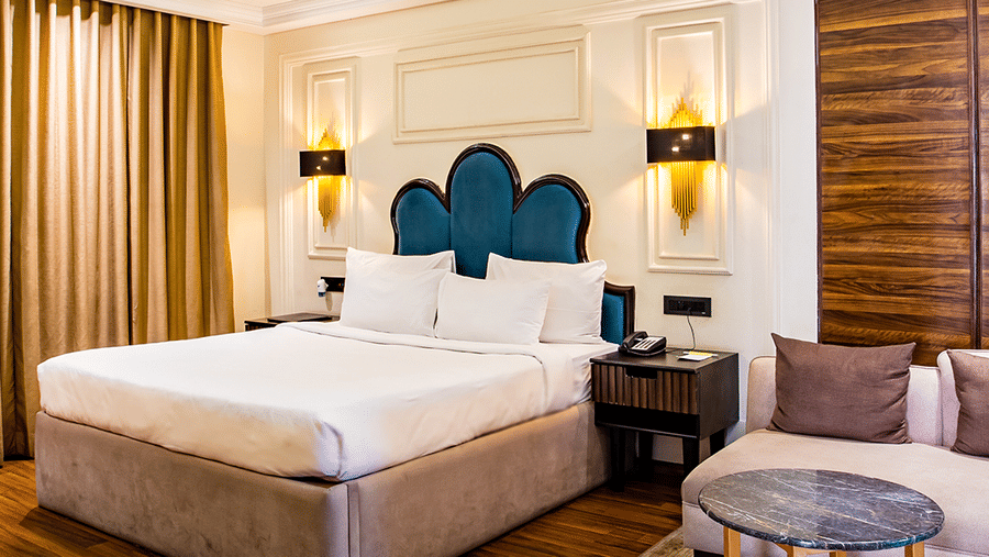 Luxurious hotel room with a king-sized bed and elegant decor with wooden panelled floors - Wedlock Greens Hotel & Resort, Dhanbad