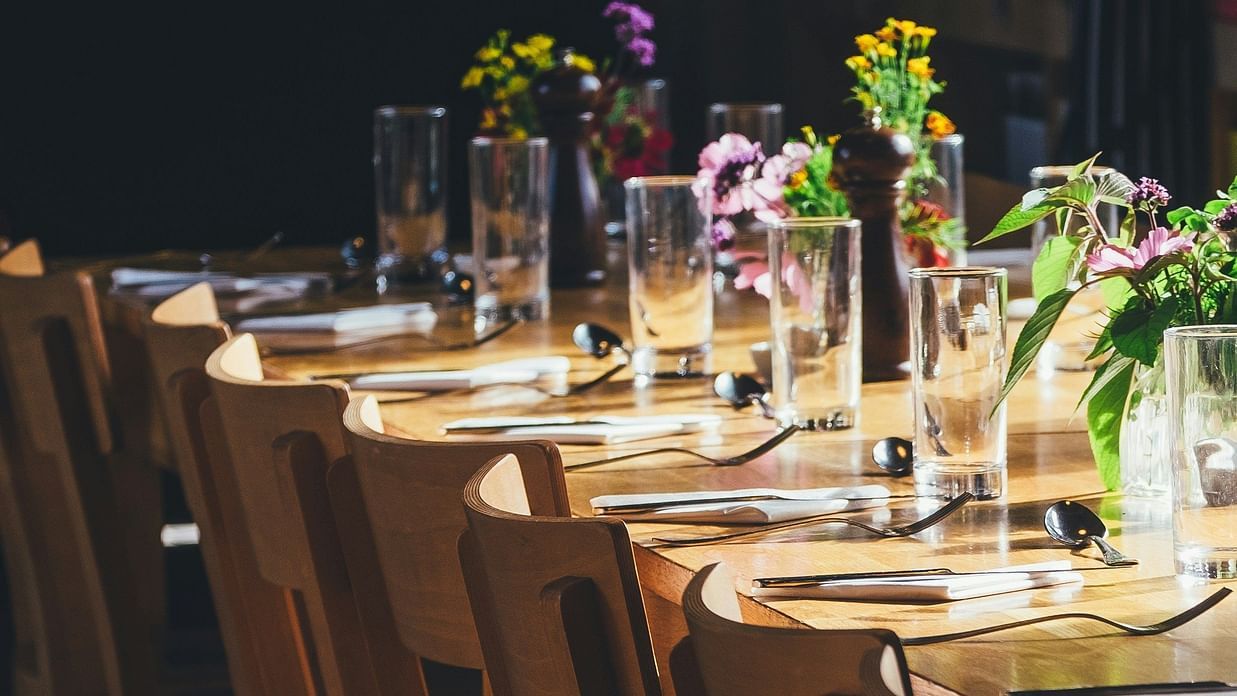 an image of cutlery placed on a  long wooden table 
