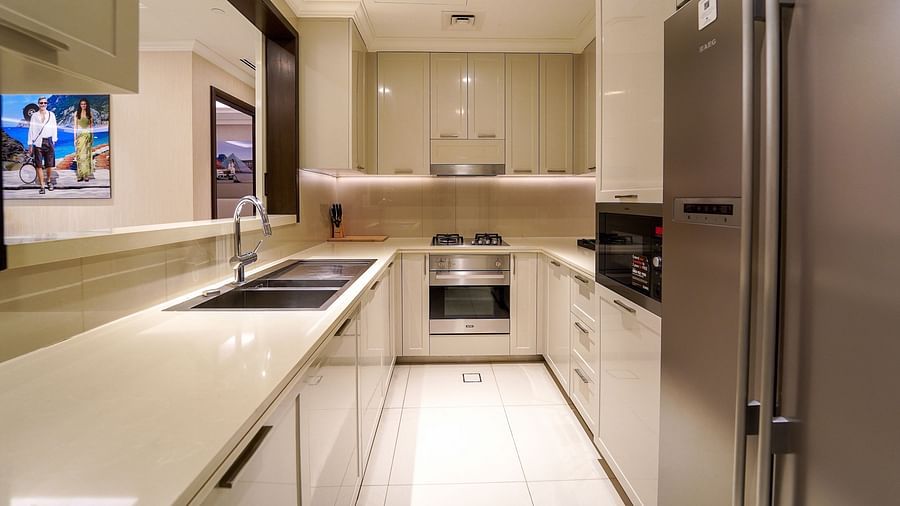 Address Fountain Views Residence Tower - the frontal view of the kitchen equipped with a sink, a fridge and shelfs