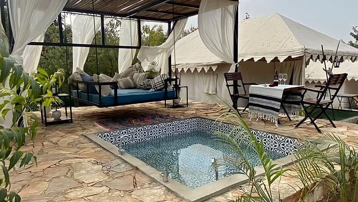 An outdoor swimming pool with a swing chair placed beside it at Valley by Grassfield.