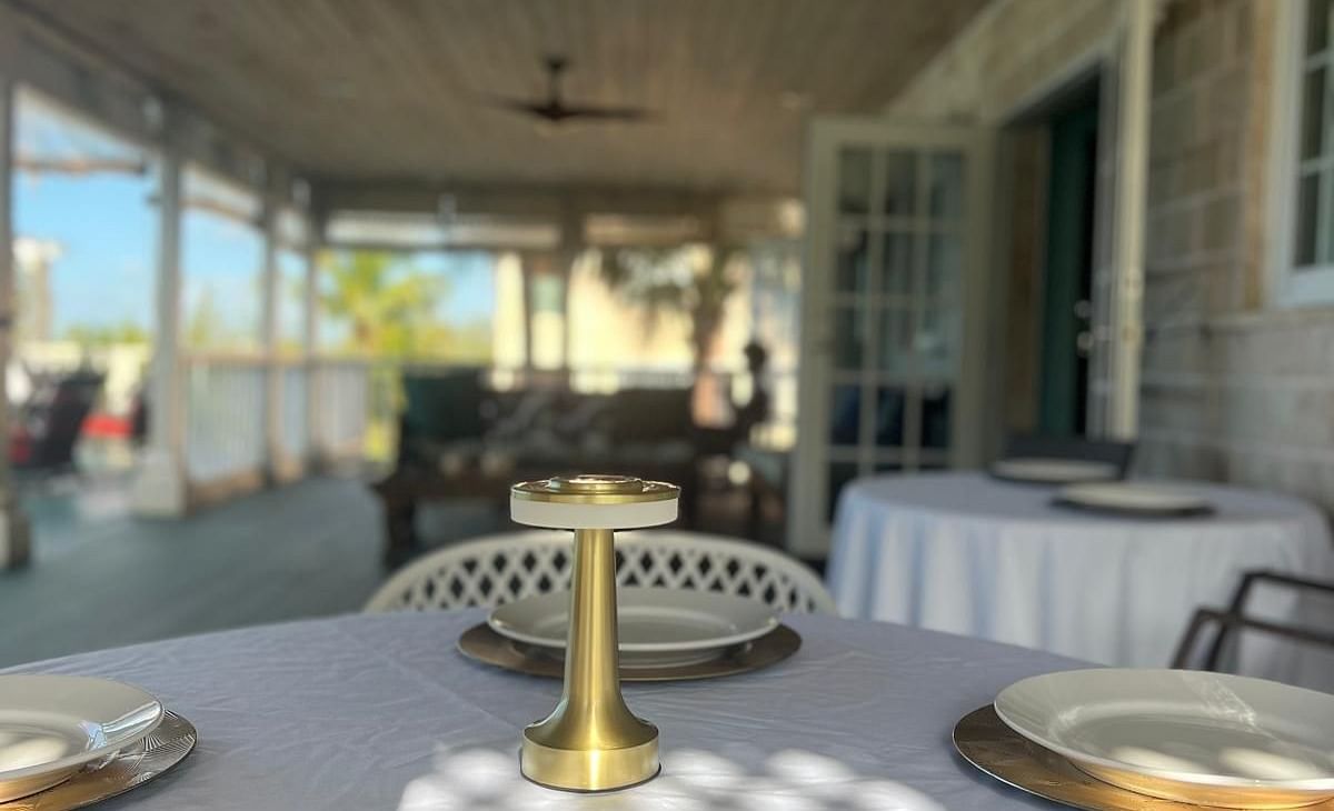 Round table with plates under a ceiling fan on a covered deck | A Stone's Throw Away