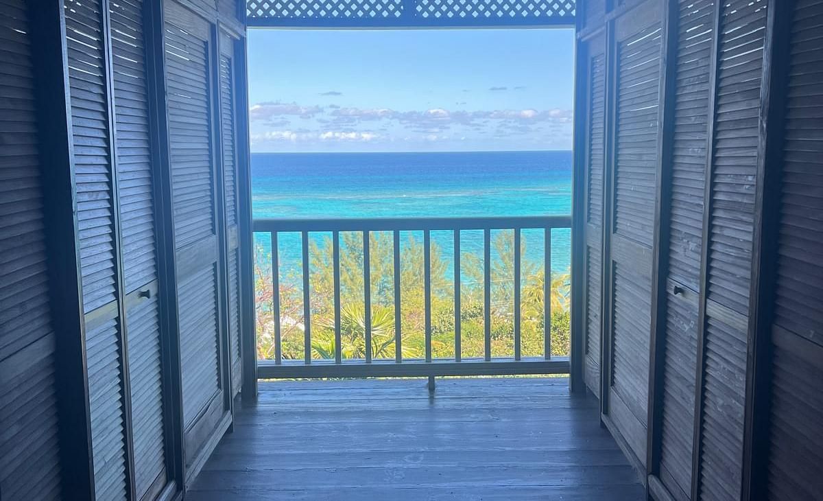 Wooden hallway leading to a balcony with ocean view | A Stone's Throw Away