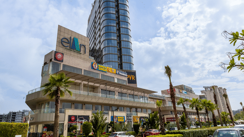 Daytime view of the tall glass tower rising above the lower commercial floors at Golden Tulip - Sector 80, Gurugram.