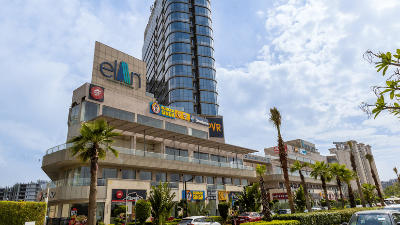 Daytime view of the tall glass tower rising above the lower commercial floors at Golden Tulip - Sector 80, Gurugram.