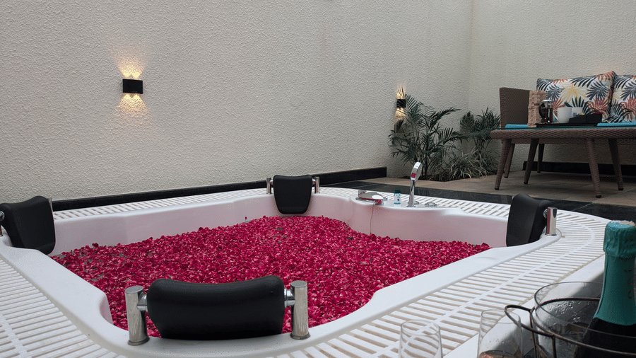 Jungle Spring Villa Private Hot Tub bathroom featuring a large jacuzzi tub filled with red rose petals at The Golden Tusk, Jim Corbett