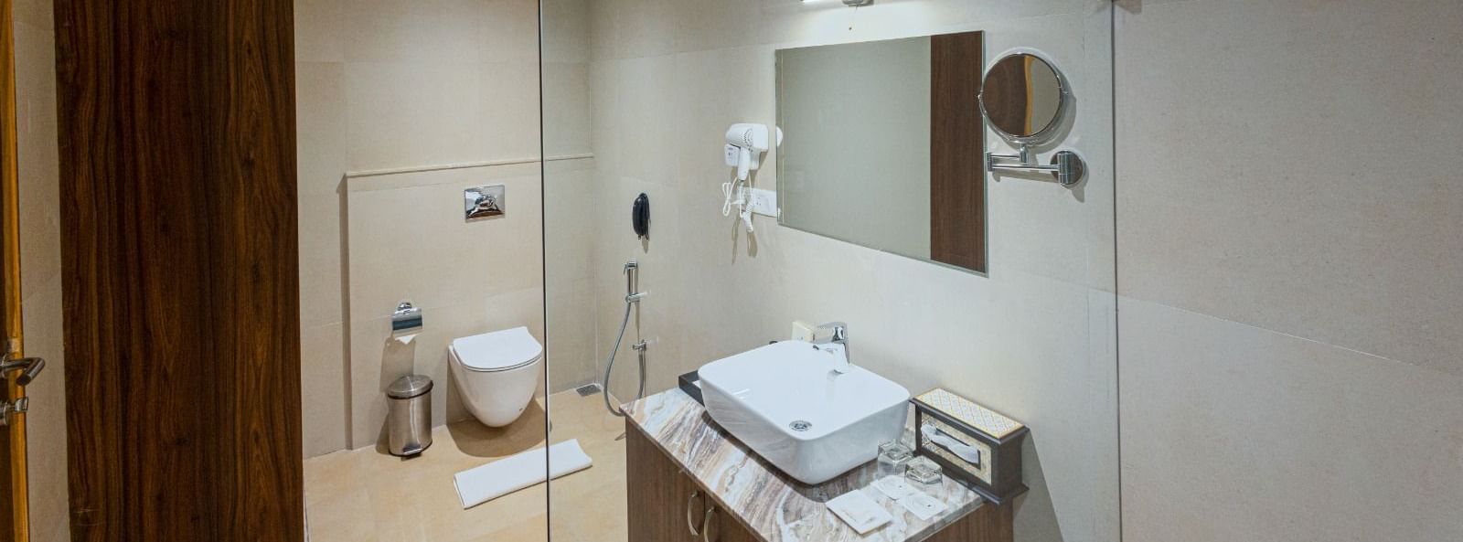 Modern bathroom at Bamboo Saa Resort & Spa, Udaipur with glass shower and vessel sink.