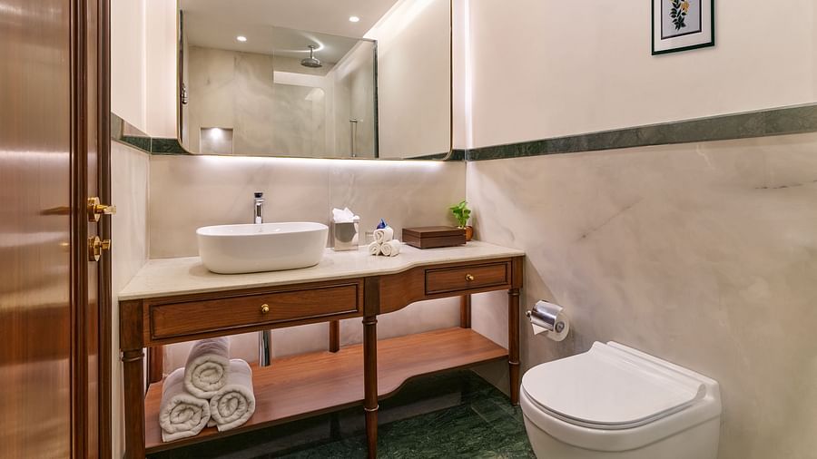 The Premium King Garden View Room at The Ummed Ahmedabad has a modern bathroom with a sleek vanity, fresh towels, and essential toiletries