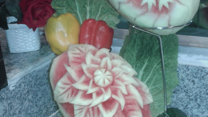 Intricately carved fruit display featuring floral patterns on melons at Central Courtyard Boutique Hotel.