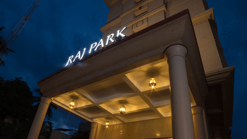Facade of Hotel raj Park, chennai with dark sky in the backdrop.