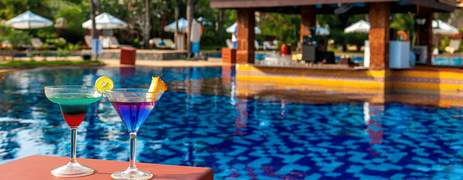 Pool bar featuring 2 cokctails and a swim up bar during daytime - Caravela Beach Resort Goa