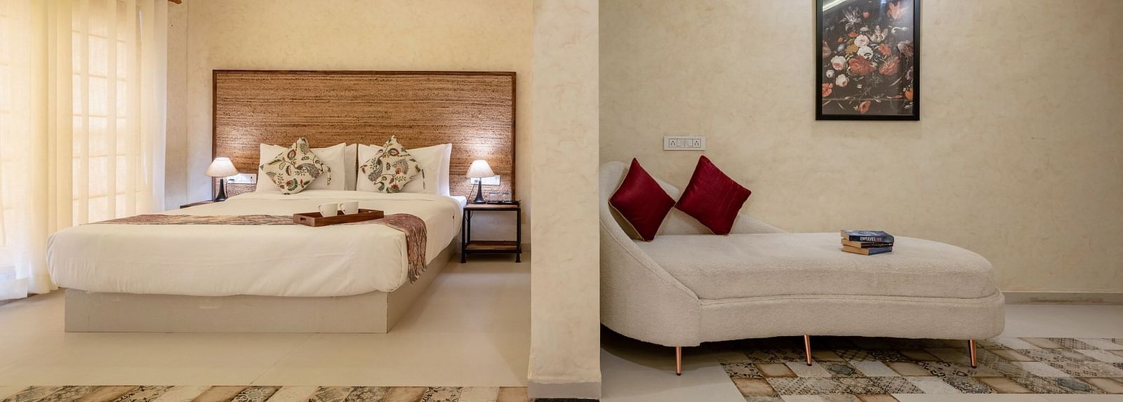 Front view of a bed and a sofa, separated by a half-wall, at Valley by Grassfield.