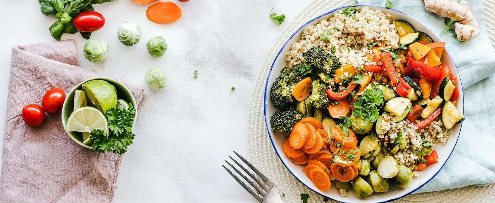 A vibrant salad bowl filled with fresh vegetables, including tomatoes, cucumbers, carrots, and greens, placed on a bright table.