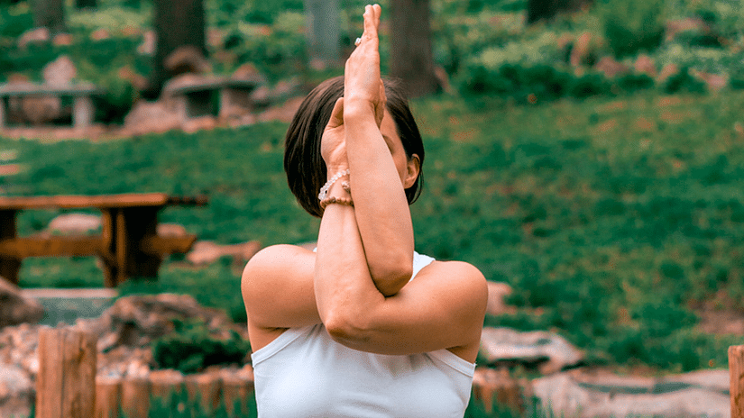 a woman doing yoga amidst lush green surrounding
