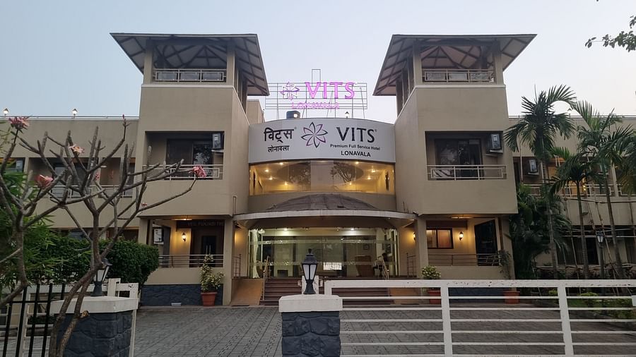 A facade image of VITS Lonavala with warm golden lighting showcasing the entry gate and greenery around
