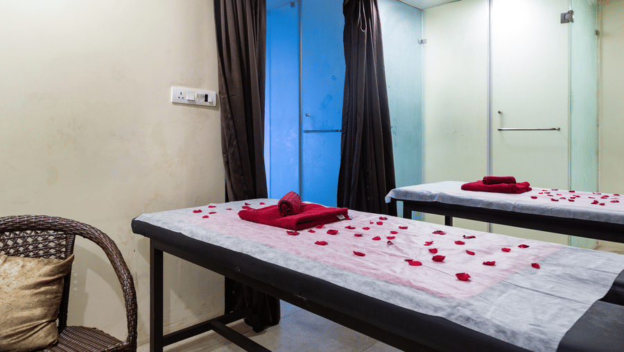 Spa room with 2 beds decorated with flower petals at Amara Grand Baga, Goa.