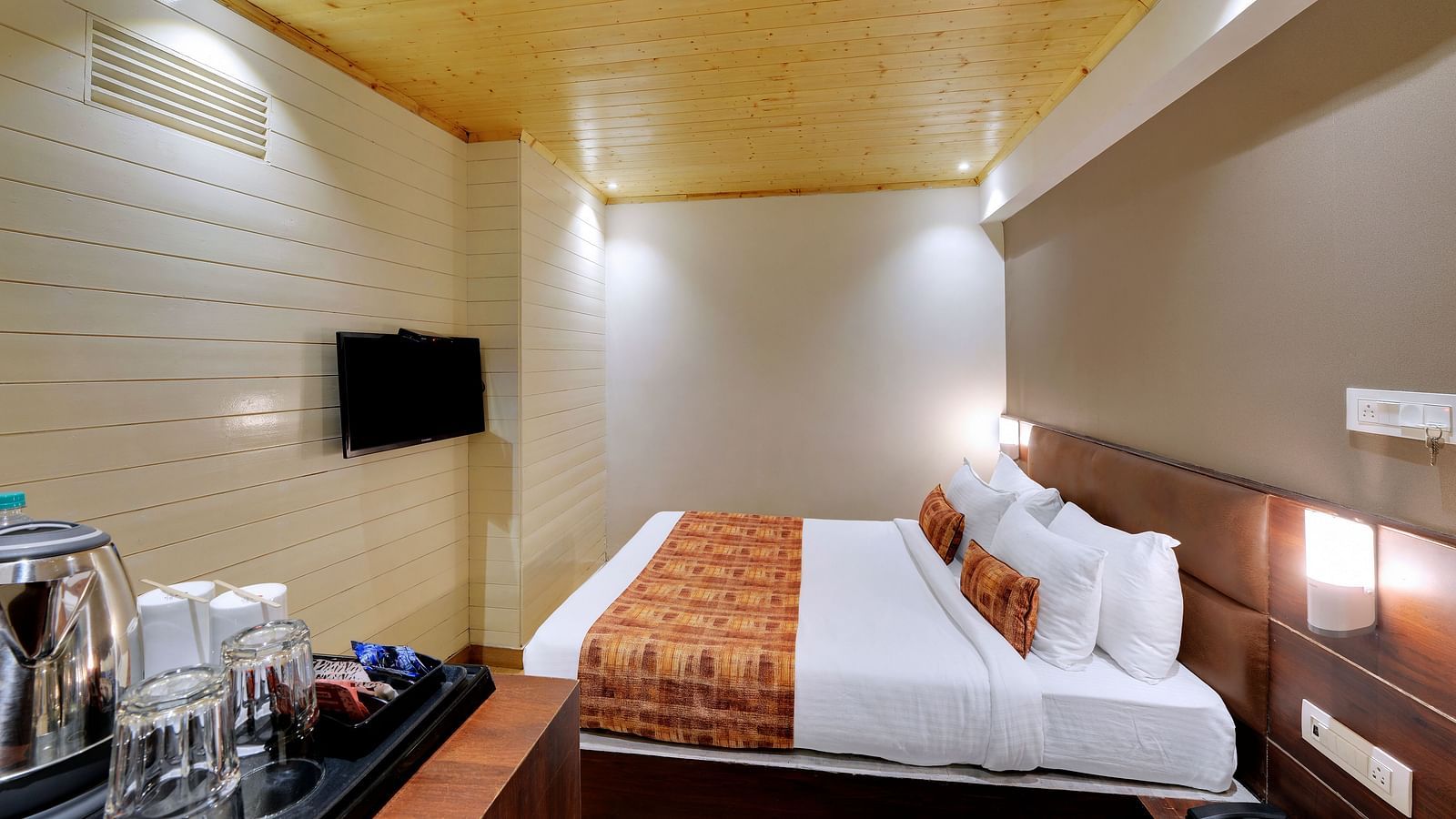 An image of a room with a queen size bed, TV and room amenities like tea coffee maker - Sumitel Vista TV Tower