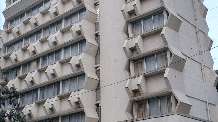 Facade image of Regency Hotel, Mumbai with a car parked outside at the entrance.