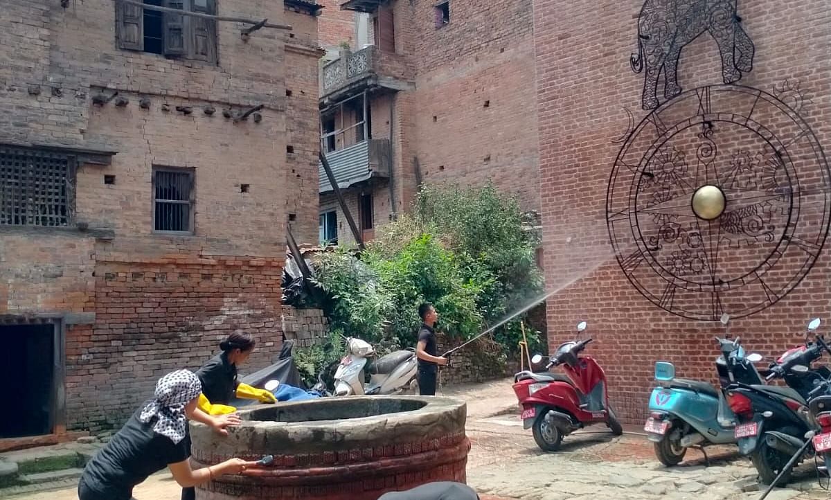 Two men seen cleaning a well